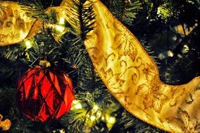 red ball and golden ribbon as a decoration of the Christmas tree