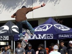 skateboarder in jump above crowd