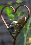metal figure of a heart and eggs on blurred background
