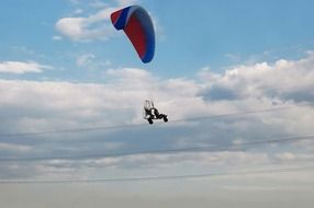 glider flies under the clouds