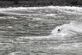 distant surfer on wave, monochrome