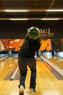 man throws a green bowling ball