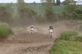 motorcyclists driving on the highway in the dust