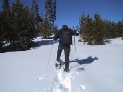 man goes snowshoeing in the snow