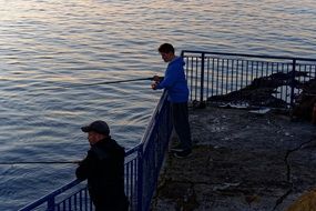 fishermen with fishing poles in the evening