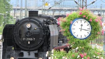 steam train and street clock at the station