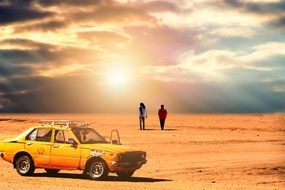 car and a couple of people in the desert sunset