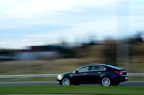 black car rides on green grass