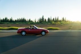 Red sport car driving Road sunny view
