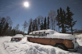 abandoned cars under the snow