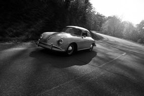 black and white photo of a retro car on the road