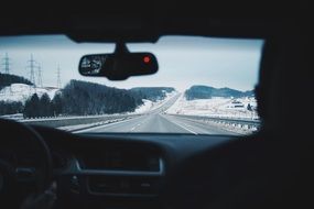 winter road through car windshield