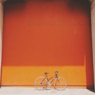 bicycle parked at orange wall