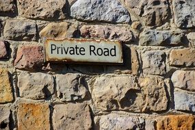 inscription on a plate on a stone wall, private road