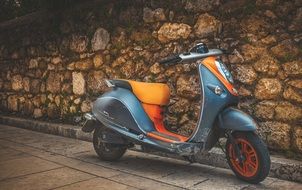 blue scooter on a stone wall background