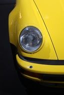 headlight of the yellow Porsche close-up