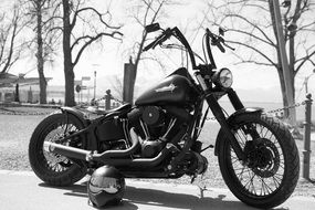 black and white photo of harley davidson next to the helmet