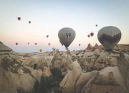 landscape of hot air balloons at sky above rocks, turkey, cappadocia