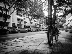 black and white photo of a bike is parked on the street