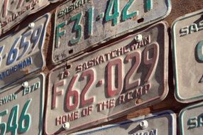 colorful vintage licence plates of cars on wall