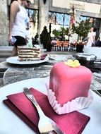 pink dessert on a table in a cafe on the street