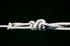 knots of white rope on a black background