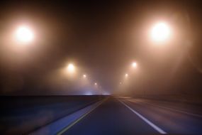 street lights above road at mist