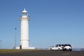 cars near the white lighthouse