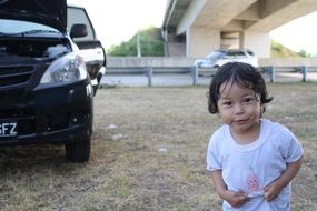 cute kid near the black car