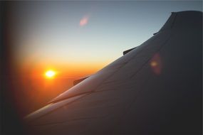 plane wing against sunset sky