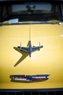 airplane figure on the hood of an old car