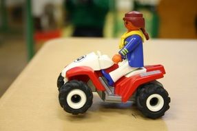 girl riding playmobil, toy on table
