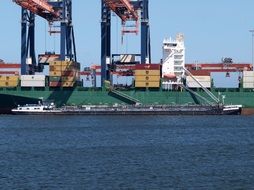 cargo ship beneath cranes in harbour, netherlands, rotterdam