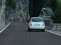 white car rides on the road