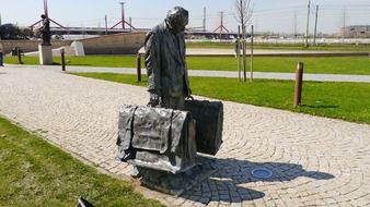 bronze statue of a man with suitcases