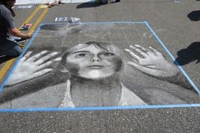 girl looking through glass, chalk drawing on street