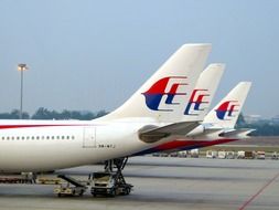 three planes side by side on field in airport