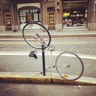 turned upside down bicycle at fence on street, finland, helsinki