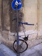 the bike is tied near the road sign