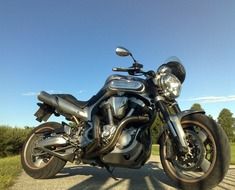 black motorcycle parked on road in countryside