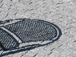 shadow from wicker chair on the pavement