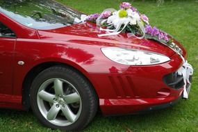 wedding decoration with flowers on a red car