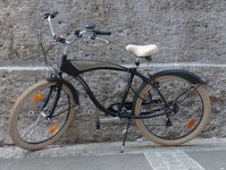 black vintage bike by the stone wall