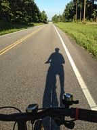 shadow of a cyclist riding a road