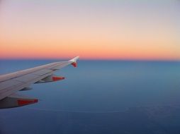 airplane wing at colorful sky