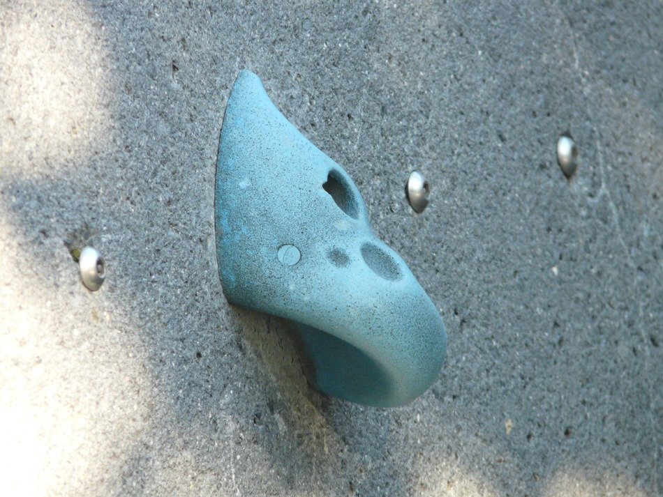 blue climbing grip on grey wall
