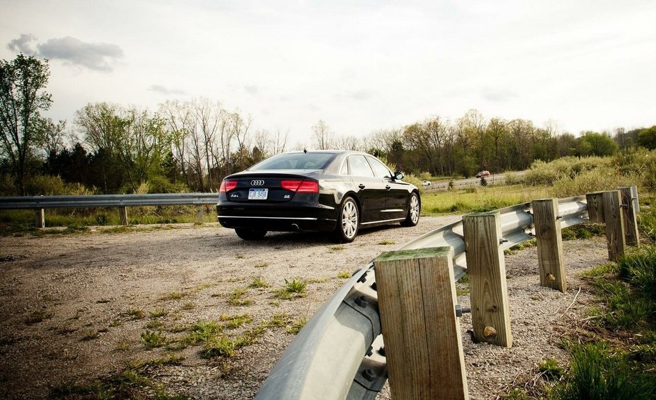 black car on the road near the wooden fence