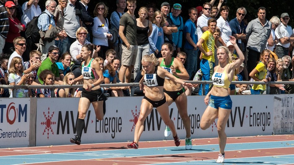 Runners against the background of the stands with viewers