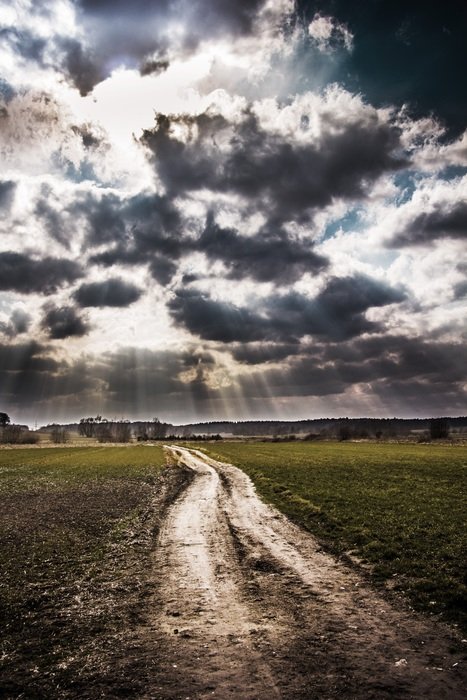 view of the dirt road and gloomy clouds