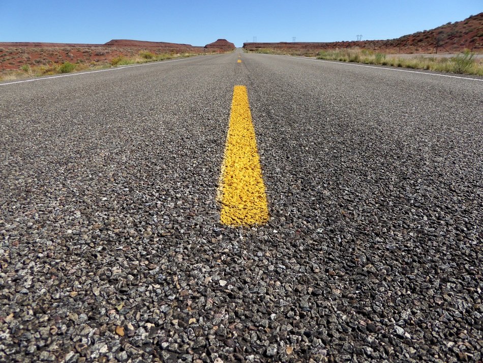 asphalt road with a yellow line in the middle